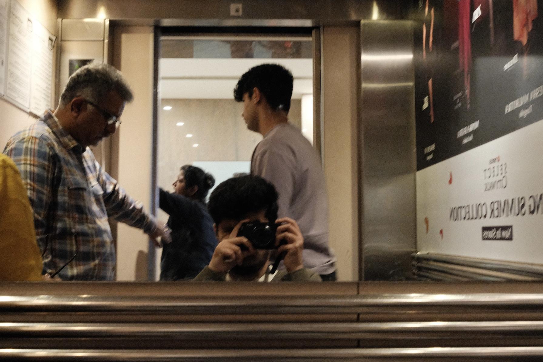 Slightly blurry mirror selfie in an elevator with a mirrorless camera.