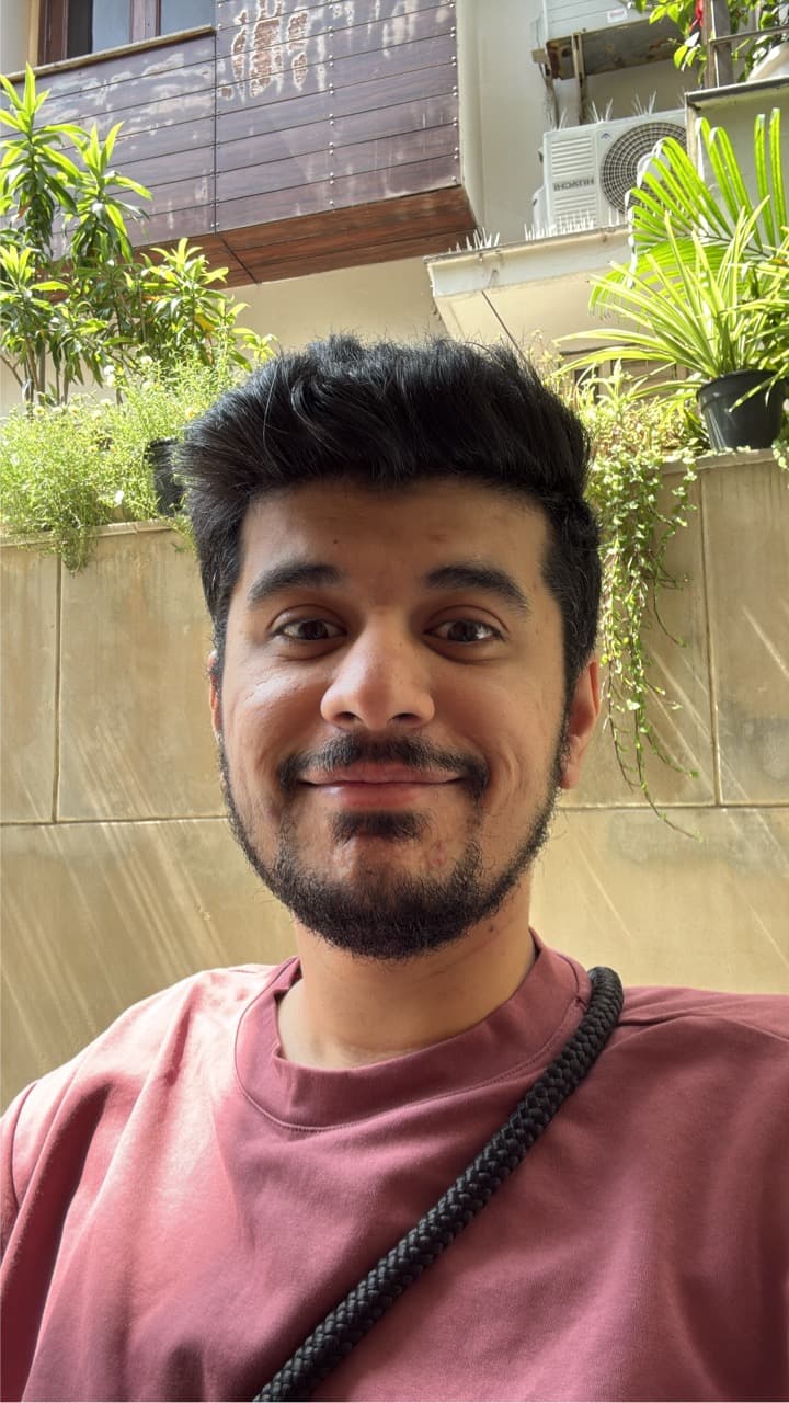 Selfie of Ratik in 2025 wearing a camera strap on his shoulder.