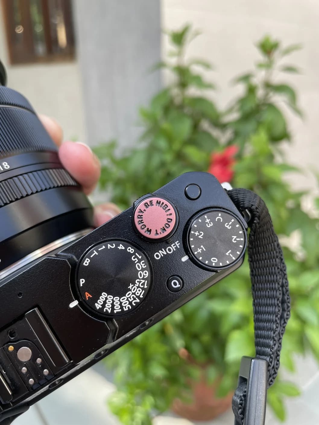 A FUJIFilm mirrorless camera around a guy's neck